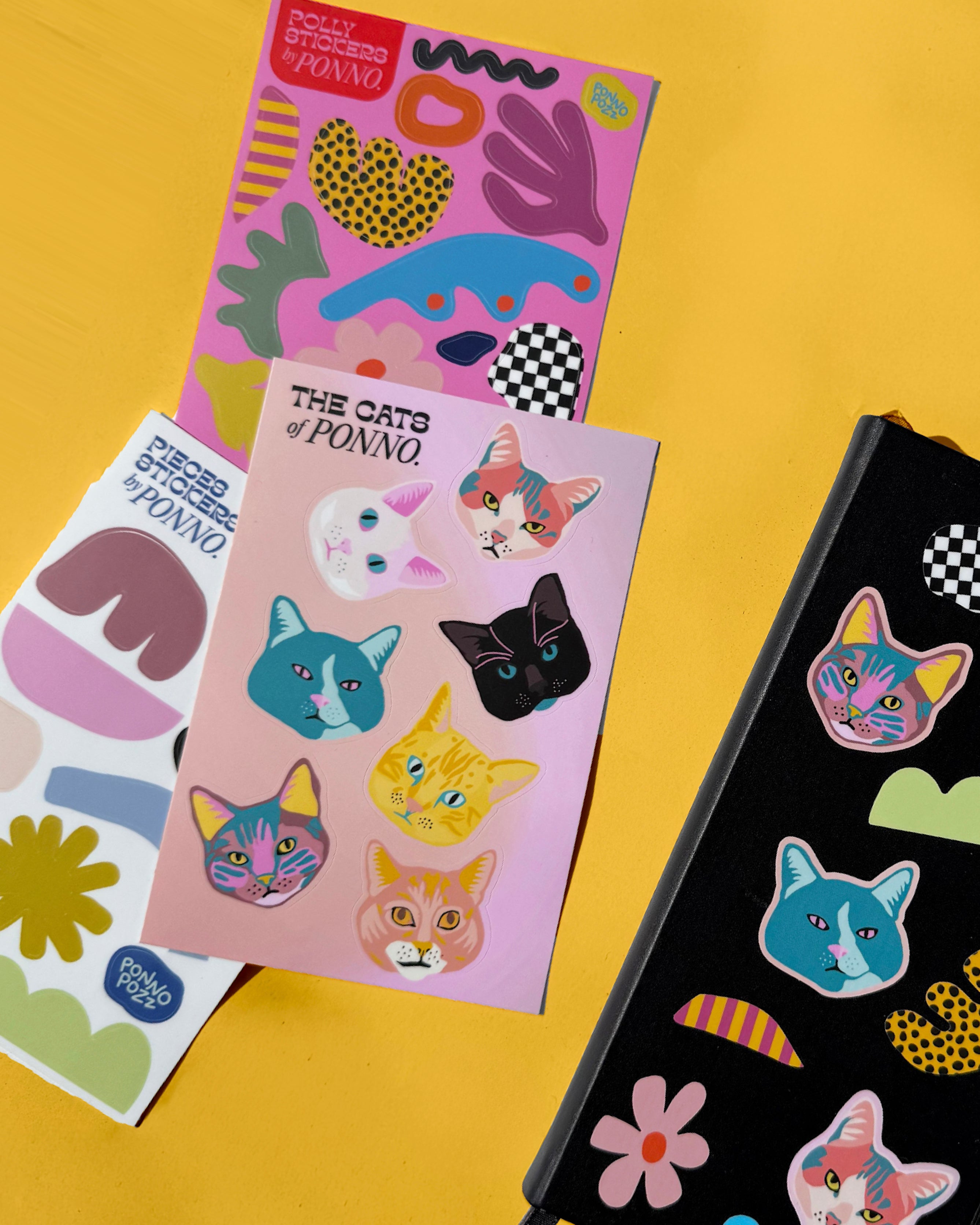 Colorful sticker sheets with cat designs on a yellow background