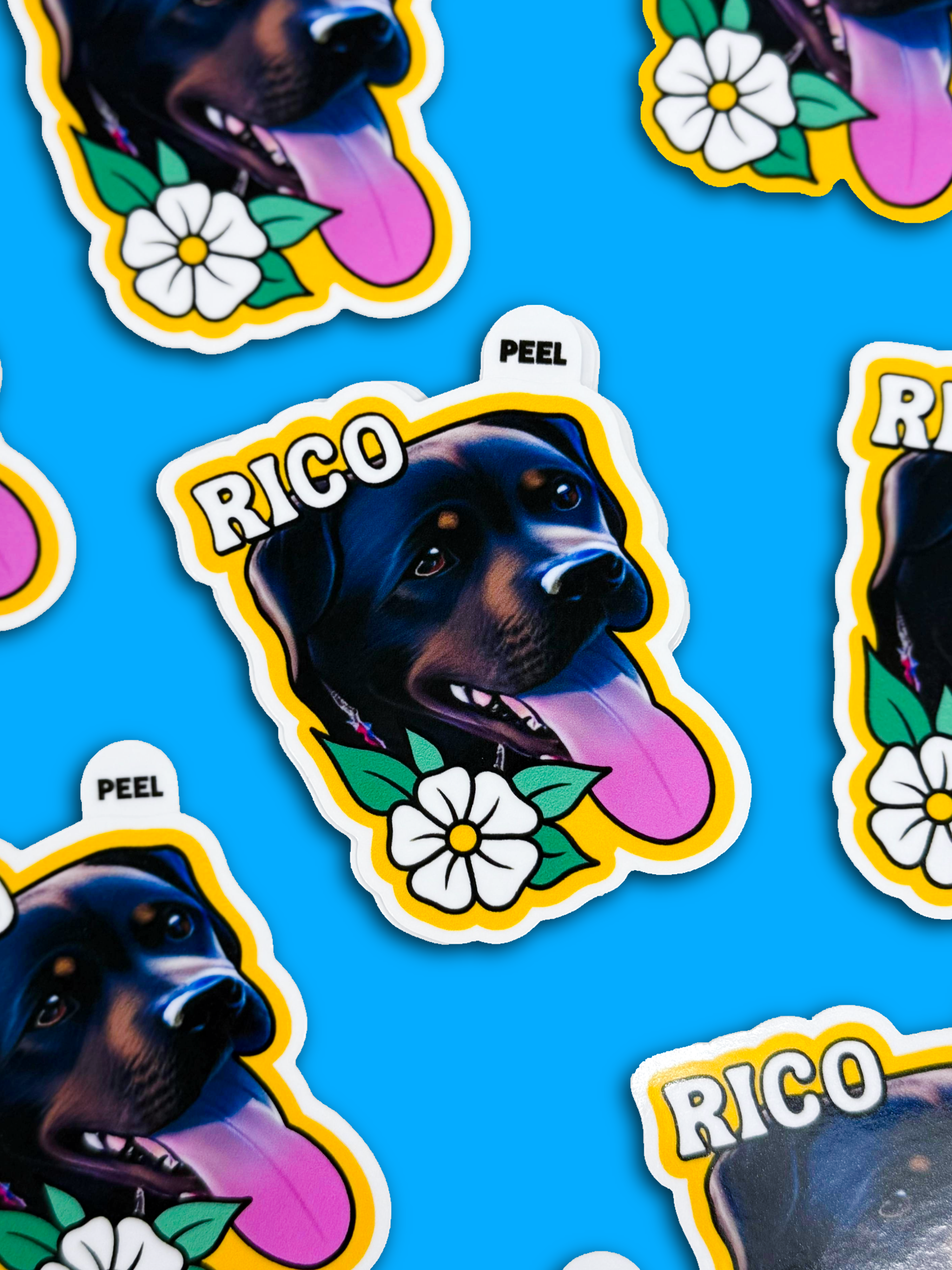 Bright peel tab stickers with a cartoon black dog's face, a pink tongue out, white flower, and "RICO" text on a vibrant blue background, conveying playfulness.
